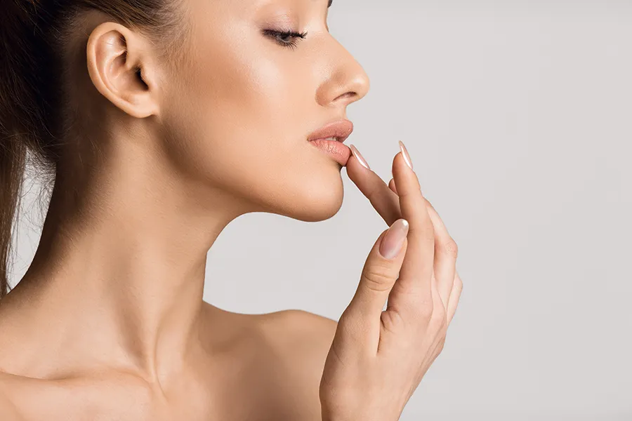 Aerolase-Neo-Laser-for-Skin-Clinic Profile of a woman with beautiful skin touches her lips. Get Aerolase Neo Laser treatment from Blessed Beauty Boutique in Greater Phoenix.