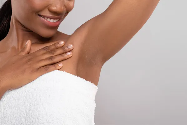 Botox-for-Excessive-Sweating-Clinic Close up of an African American woman wrapped in a white towel showing her underarm area. Visit Botox® for excessive sweating specialist Blessed Beauty Boutique in Greater Phoenix.
