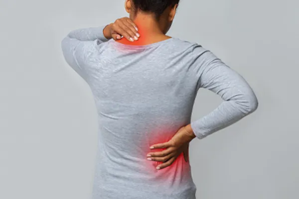 Fibromyalgia-Clinic An image from behind of a woman suffering from Fibromyalgia holding her hands on her neck and lower back. Get fibromyalgia care from Blessed Beauty Boutique in Greater Phoenix.