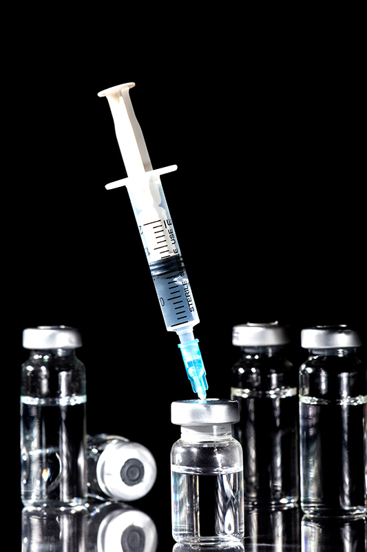 NAD-Injection-Treatment Close-up of a syringe piercing a vial of fluid. Get NAD+ injections from Blessed Beauty Boutique in Greater Phoenix.