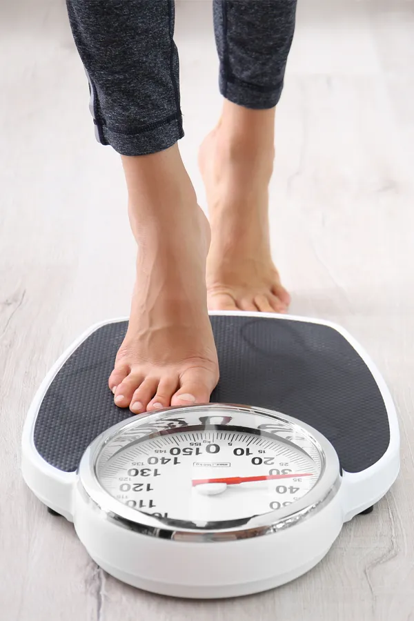 Obesity-Treatment Close up of feet stepping onto a scale. Receive expert functional medicine for obesity treatment by Blessed Beauty Boutique in Greater Phoenix.