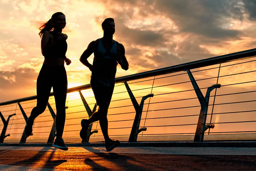 Performance-Enhancing-Peptides-Doctor A couple jogging on a bridge at sunrise, representing performance enhancing peptide therapy from Blessed Beauty Boutique in Greater Phoenix.